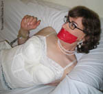 trannie Sandra in self-bondage with handcuffs, anklecuffs, tape gag